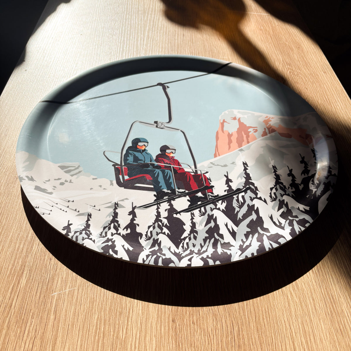 Plateau décoratif inspiré du Dévoluy avec skieurs sur un télésiège et Pic de Bure en arrière-plan