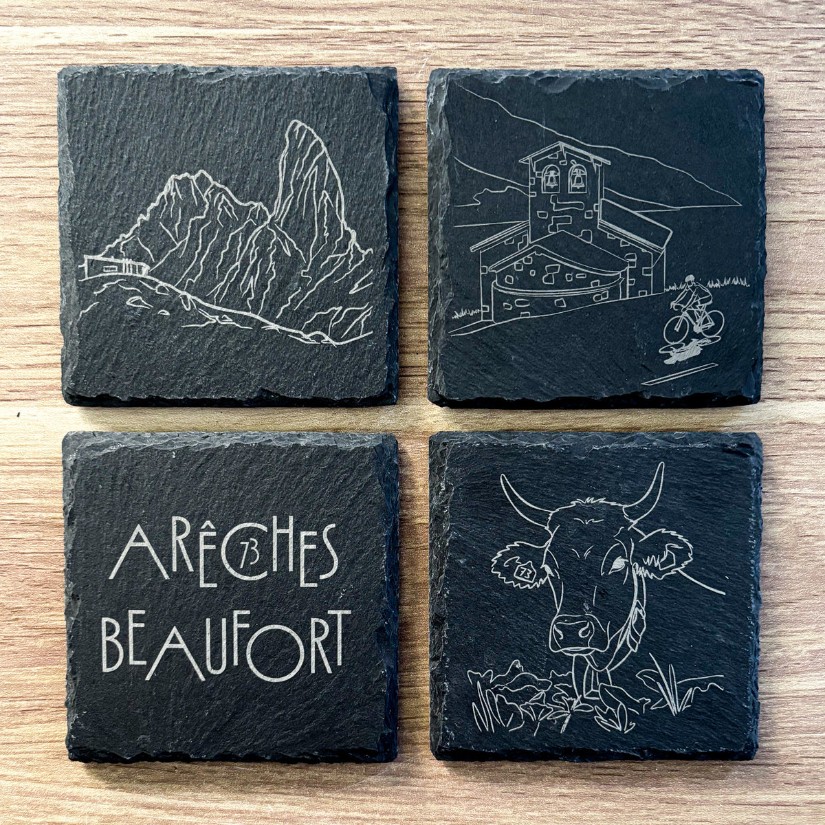 Lot de quatre dessous de verre en ardoise Arêches-Beaufort, gravés avec des illustrations de la vache Tarine, de la Pierra Menta et du Cormet de Roselend